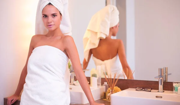 Giovane donna attraente in piedi davanti allo specchio del bagno — Foto Stock