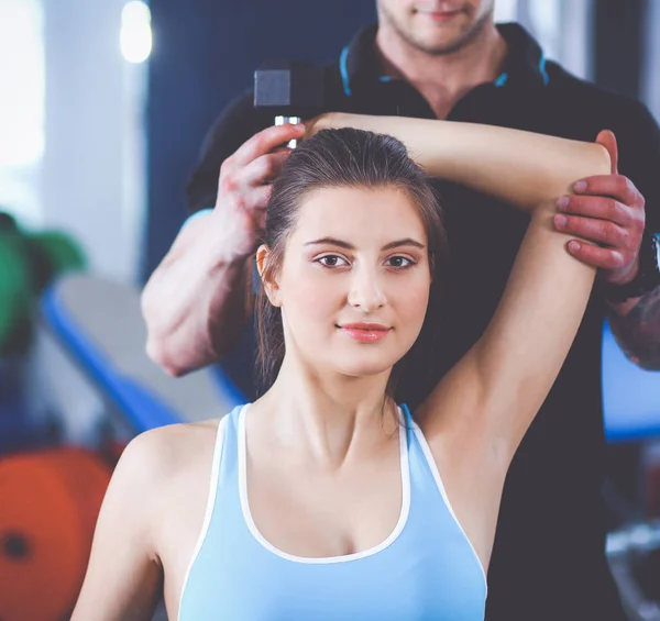 Beautiful woman at the gym exercising with her trainer — Stock Photo, Image