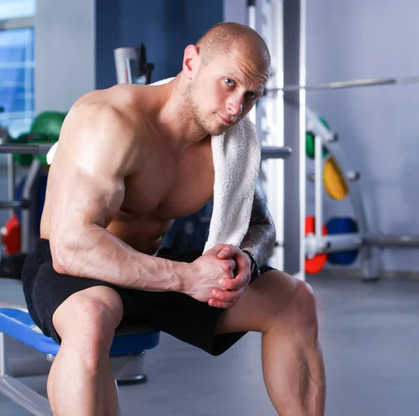 Giovane bell'uomo si siede dopo l'allenamento in palestra — Foto Stock