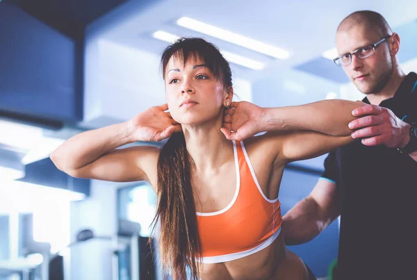 Schöne Frau im Fitnessstudio beim Training mit ihrem Trainer — Stockfoto