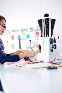 Çalışırken dikiş diken genç bir kadın. .