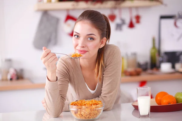 Ler attraktiv kvinna äter frukost i köket interiör. Leende kvinna attraktiv. — Stockfoto