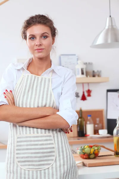 Mujer joven sonriente preparando ensalada en la cocina . —  Fotos de Stock