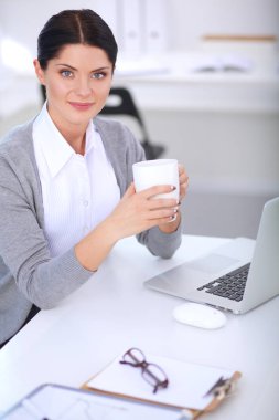Ofiste Kupası ile masaya oturan genç iş kadını. Genç iş kadını