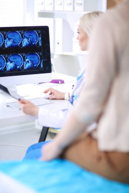 Doktor ve hasta masada otururken bir şey tartışıyorlar. Tıp ve sağlık hizmetleri kavramı. Doktor ve hasta.