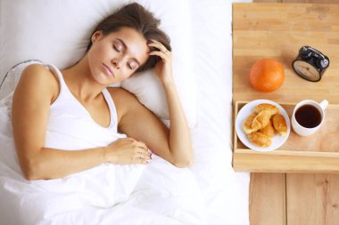 Genç ve güzel bir kadın yatakta yatıyor..