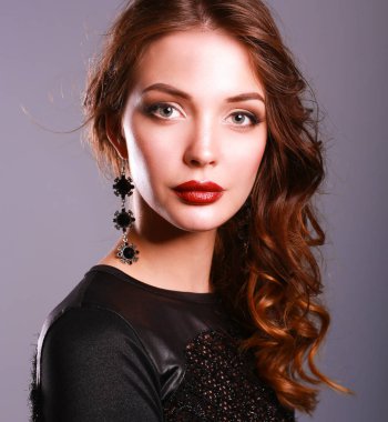 Siyah elbiseli, akşam makyajlı güzel bir kadın.