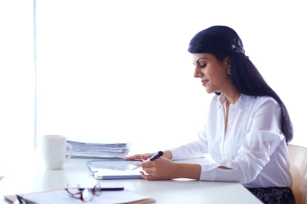 Mujer con documentos sentada en el escritorio — Foto de Stock