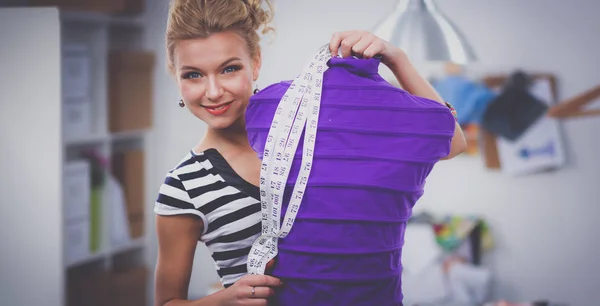 Smiling fashion designer standing near mannequin in office — Stock Photo, Image