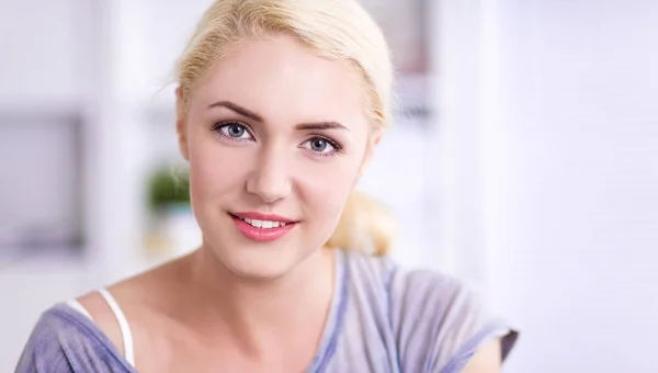 Jonge mooie vrouw zitten op de bank in haar kamer — Stockfoto