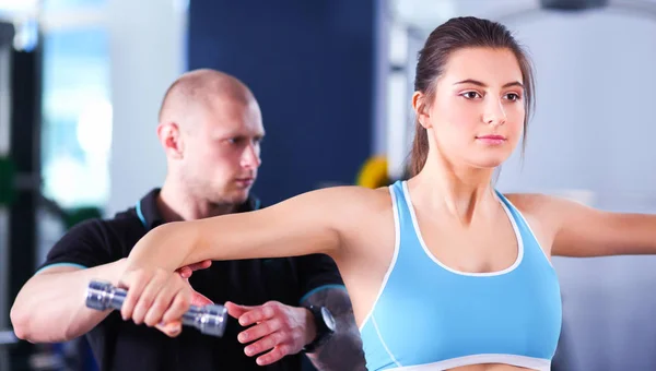 Schöne Frau im Fitnessstudio beim Training mit ihrem Trainer — Stockfoto