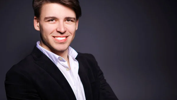 Porträt eines lächelnden jungen Mannes auf grauem Hintergrund — Stockfoto