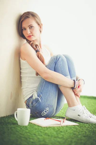 Hermosa mujer sentada en el suelo y sosteniendo una taza. Hermosa mujer — Foto de Stock