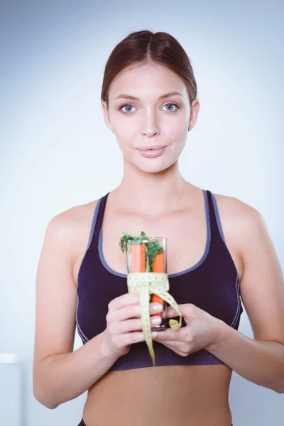 Mulher segurando um copo cheio de salada de frutas frescas com uma fita métrica ao redor do copo. — Fotografia de Stock