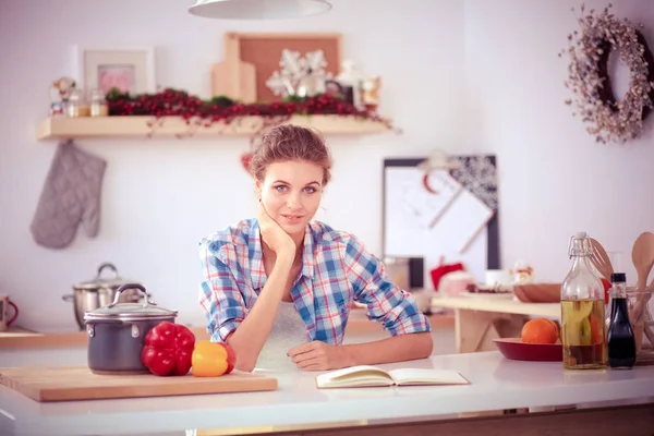 Smiling woman holding her cellphone in the kitchen. Smiling woman. — Stock Photo, Image