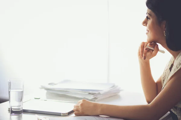 Mujer con documentos sentada en el escritorio — Foto de Stock