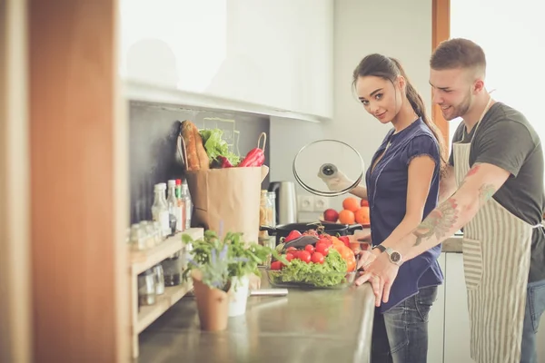 Par matlagning tillsammans i sitt kök hemma — Stockfoto