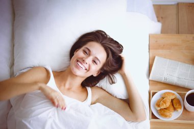 Genç ve güzel bir kadın yatakta yatıyor..