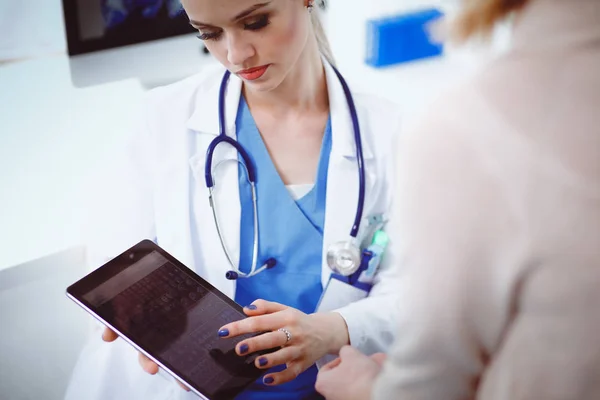 Doktorn och patienten diskuterar något när de sitter vid bordet. Medicin och hälsovård koncept. Läkare och patient — Stockfoto