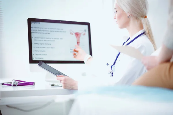 Doktorn och patienten diskuterar något när de sitter vid bordet. Medicin och hälsovård koncept. Läkare och patient — Stockfoto