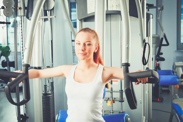 Fata frumoasa la sala de sport exercitarea pe antrenori. Fata frumoasa — Fotografie, imagine de stoc