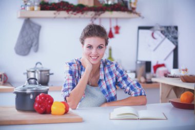 Mutfakta cep telefonunu tutan gülümseyen kadın. Gülümseyen kadın.