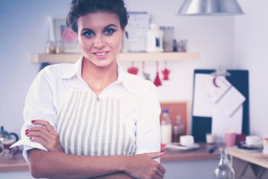 Gülümseyen genç kadın mutfakta salata hazırlık.