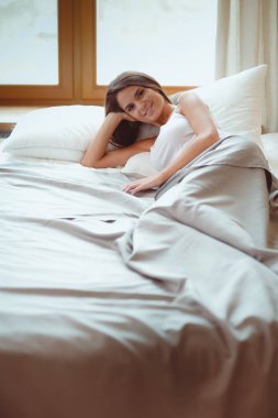 Evdeki yatakta uzanmış güzel esmer