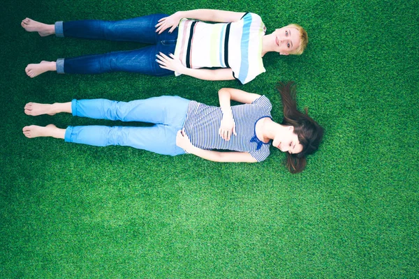 Jovens mulheres deitadas na relva verde. Mulheres jovens — Fotografia de Stock