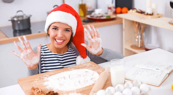 Mutlu genç bayan gülümsüyor Noel hazırlıklarıyla eğleniyor Noel Baba şapkası takıyor. — Stok fotoğraf