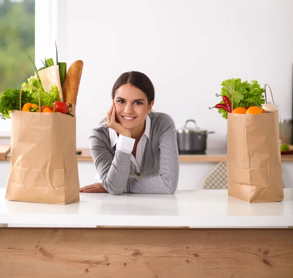 一个微笑的女人坐在厨房做饭的画像 — 图库照片