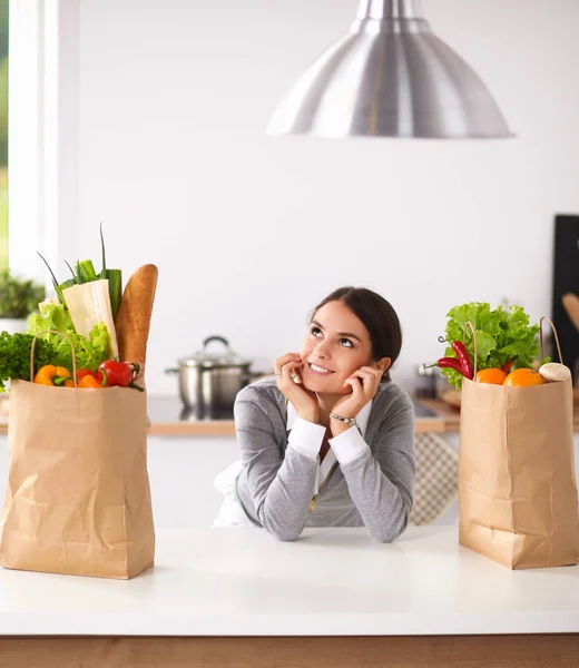 一个微笑的女人坐在厨房做饭的画像 — 图库照片