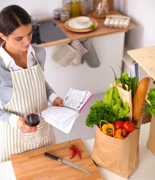 Mujer haciendo comida saludable de pie sonriendo en la cocina — Foto de Stock