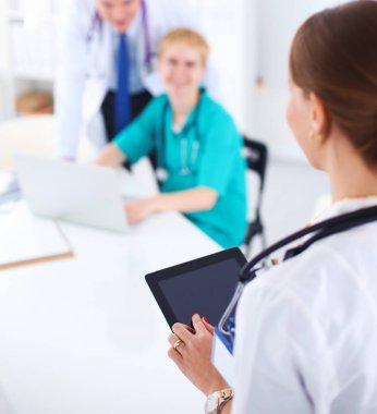 Masada oturan gülümseyen güzel genç bayan doktor.