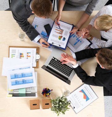 İş adamları iş toplantısında, ofiste oturup tartışıyorlar.