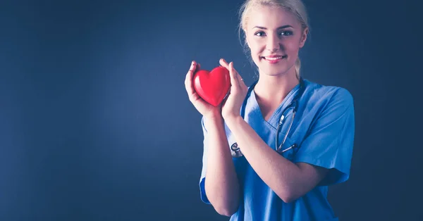 Arzt mit Stethoskop hält Herz, isoliert auf grauem Hintergrund — Stockfoto