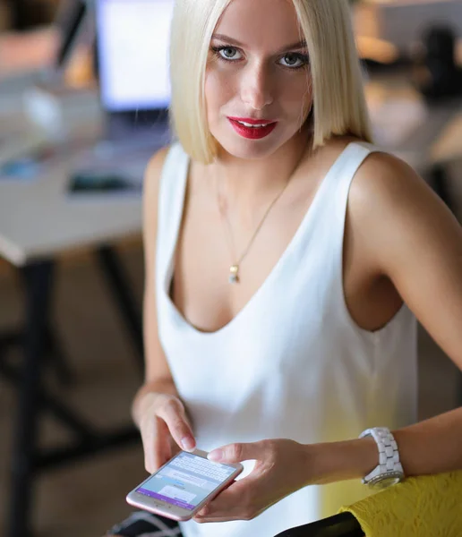 Vrouw designer gebruiken op mobiele telefoon in kantoor — Stockfoto
