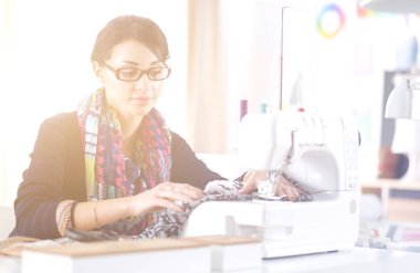 Çalışırken dikiş diken genç bir kadın. .