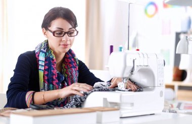 Çalışırken dikiş diken genç bir kadın. .