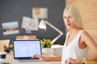 Moda tasarımcıları stüdyoda çalışıyor. Masanın üzerinde oturuyorlar..