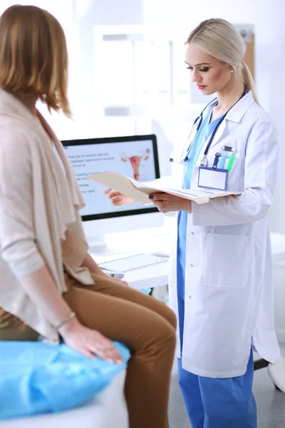 Doktorn och patienten diskuterar något när de sitter vid bordet. Medicin och hälsovård koncept. Läkare och patient — Stockfoto