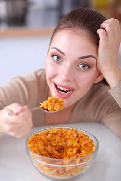 Mujer atractiva sonriente desayunando en el interior de la cocina. Mujer atractiva sonriente . — Foto de Stock