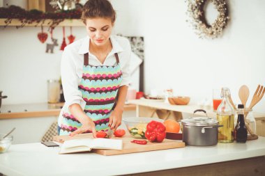Gülümseyen genç kadın mutfakta salata hazırlık.