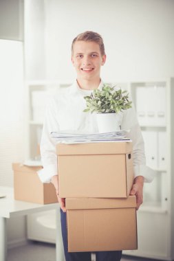 Gri arka plan üzerinde oturan gülümseyen genç adam portresi. Genç adam portresi