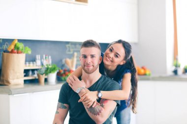 Güzel genç çift evde mutfakta eğleniyor.