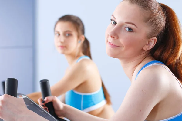 Groupe de personnes au gymnase faisant de l'exercice sur des entraîneurs croisés. Les gens au gymnase — Photo