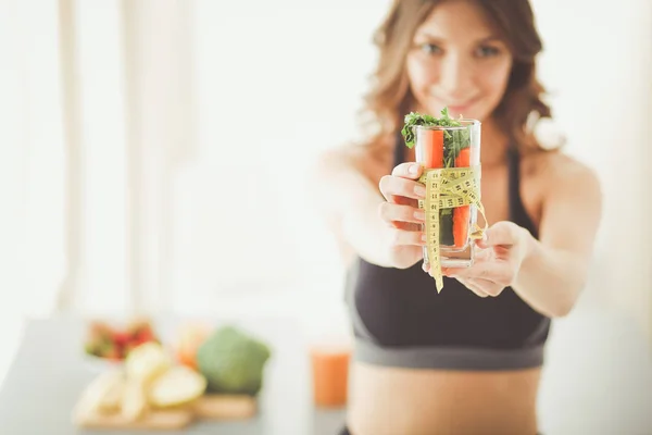 Mulher segurando um copo cheio de salada de frutas frescas com uma fita métrica ao redor do copo. — Fotografia de Stock