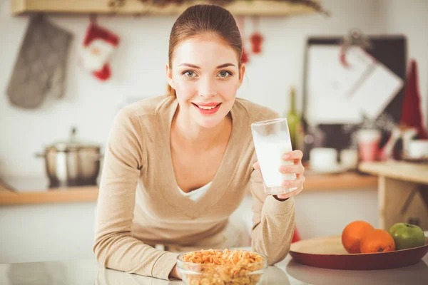 Smiling attractive woman having breakfast in kitchen interior. Smiling attractive woman.