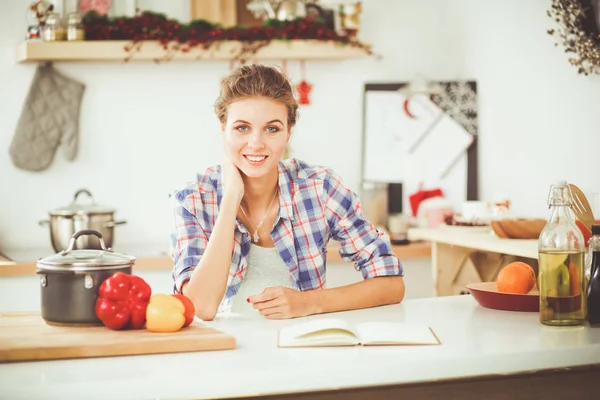 Lachende vrouw met haar mobiel in de keuken. Lachende vrouw. — Stockfoto