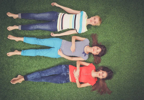 Des jeunes femmes allongées sur de l'herbe verte. Jeunes femmes — Photo